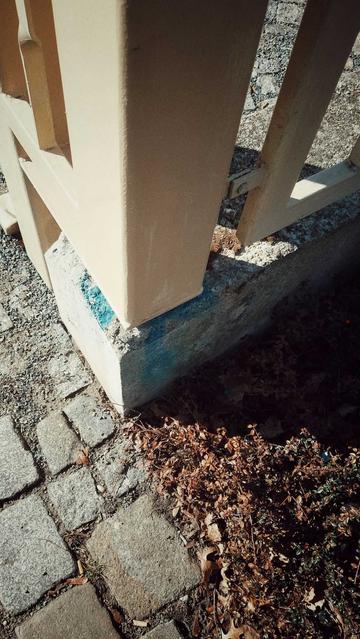 Iron fence on a concrete foundation. Seen is the corner of the perimeter isolated by this structure. Outside, rocky floor and thorny low brown bushes.