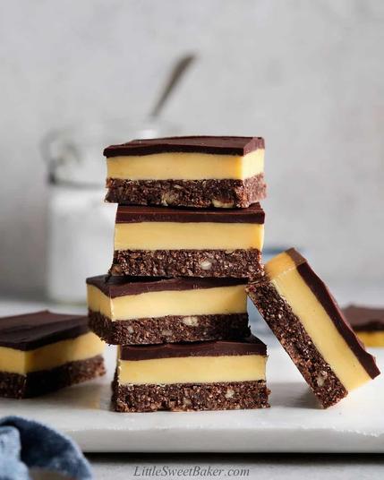 Nanaimo bars. A square sliced dessert with a chocolate crumb, coconut, nut bottom layer, custard cream middle layer, and thin melted chocolate top layer