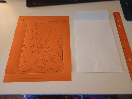 a page showing the outlines of four unfolded pyramids, arranged so that they fit inside a 9x6 rectangle. a matching envelope is shown for reference.