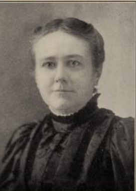 Caroline Frances Hamilton, from an 1899 publication; a white woman with hair parted center and dressed simply to the nape, wearing a dark dress with a high lace-trimmed collar