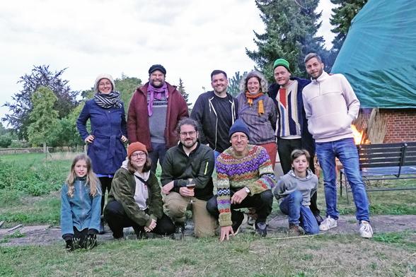 Elf Personen in zwei Reihen gucken in die Kamera. Die vordere Reihe kniet. Die Personen dahinter stehen.