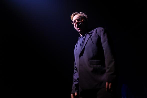 Here's me singing in an oversized suit jacket with a hoodie underneath, in dramatic theatre lighting 

Photographer: Juri Hiensch