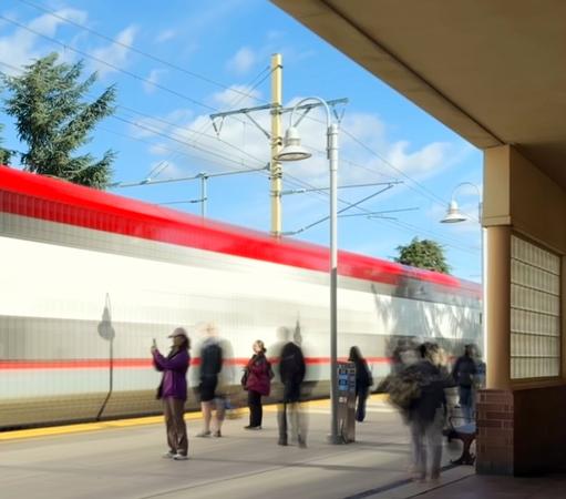 Commuters gather at a blur of a train arteries at a station. They are also various degrees of blur depending on how much they were moving.