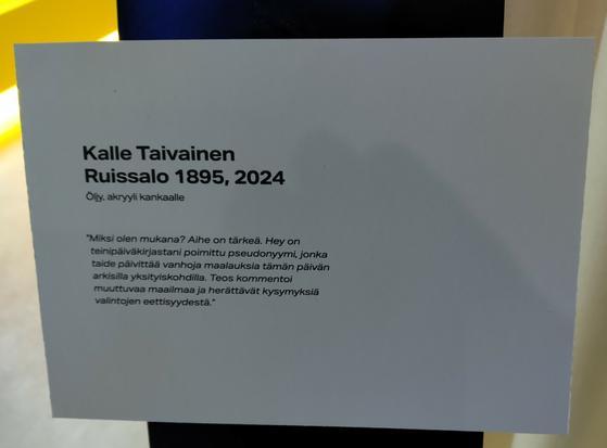Kyltti taulun yhteydessä.

Lukee: Kalle Taivainen Ruissalo 1895, 2024
Öljy, akryyli kankaalle
"Miksi olen mukana? Aihe on tärkeä. Hey on teinipäiväkirjastani poimittu pseudonyymi, jonka taide päivittää vanhoja maalauksia tämän päivän arkisila yksityiskohdilla. Teos kommentoi muuttuvaa maailmaa ja herättää kysymyksiä valintojen eettisyydestä."