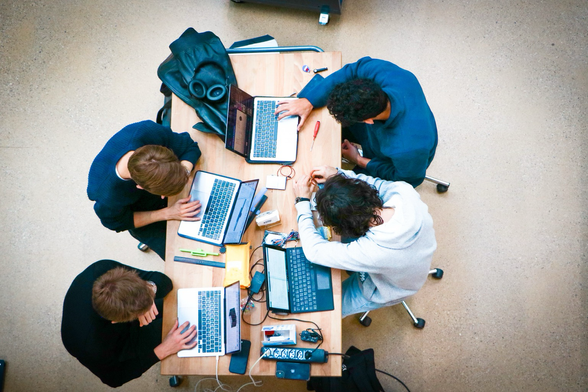 Students sitting around a table working together.