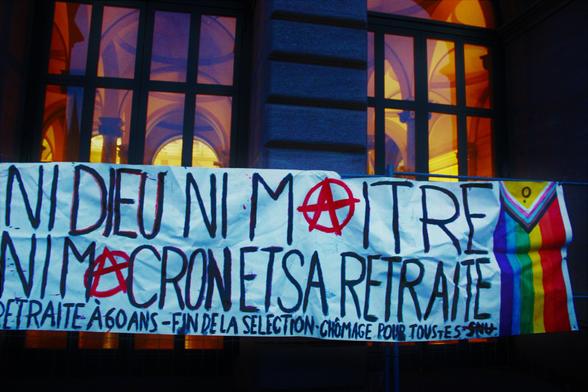 Banderole "Ni dieu, ni maitre, ni Macron et sa retraite - Retraite à 60 ans, fin de la sélection, chômage pour tou•tes, non au SNU"