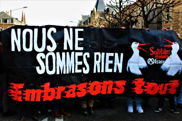Banderole "Nous ne sommes rien : embrasons tout" avec des cigognes en colère