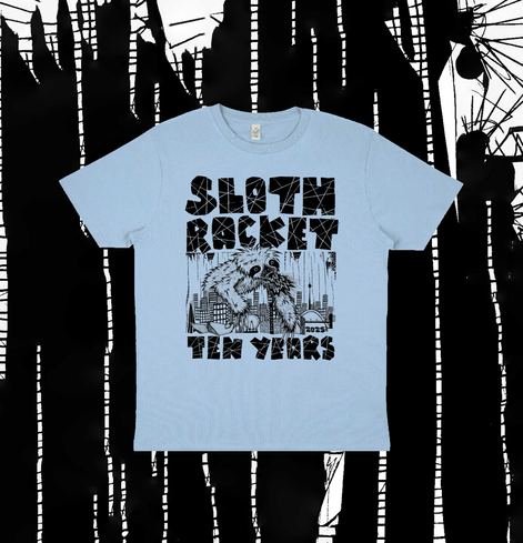 A pale blue t-shirt with a hand drawn design of a giant sloth climbing over a cityscape. Some big blocky text around the image reads ‘SLOTH RACKET TEN YEARS’.