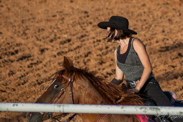 A horse being ridden by a woman rider appears to come perilously close to the railing.