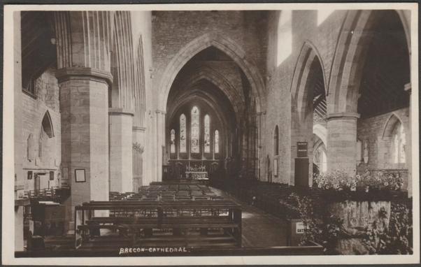 Monochrome real photographic postcard showing a view of the interior of Brecon Cathedral in Breconshire.
Publisher not stated, not numbered, c.1930s.
Postally unused.
Good condition, with very slight corner bumps, but light but large bend just below right half of top edge.