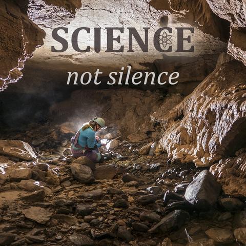 A square photograph with text at the top saying SCIENCE (dark, bold, with a test tube for the "I" and atom symbol for "C") not silence (in light color on dark).

Photo is of a person with long hair in a cave wearing purple and teal, inspecting something in a net they are holding in their hand. They sit in a cobblestone streamway, with some flowstone on the right.