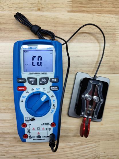 Morse code paddle connected to a PeakTech multimeter. Display shows "CQ" in CW-mode. Dial of the multimeter set to CW.