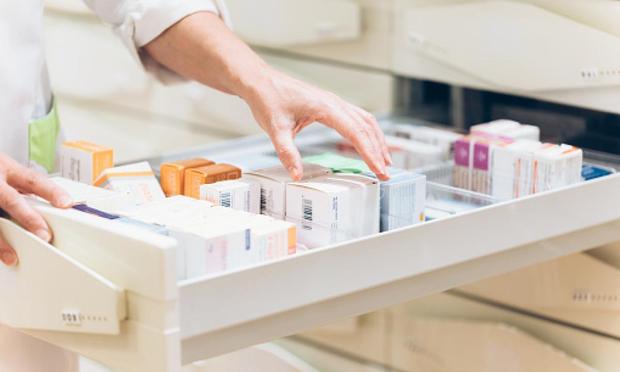 Farmacéutico sacando a mano medicamentos del cajón. (Getty Images)