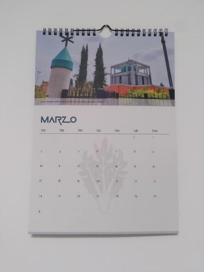 Pagina del mese di marzo del calendario Chiese Brutte 2025-26.  La chiesa del mese è quella di Tossignano (BO) intitolata al Beato Giovanni Tavelli. È una struttura in cemento quadrata con una cupola di un improbabile verde acqua e circondata da travi di cemento, tipo avessero paura che scappasse. Il campanile ha il tetto dello stesso colore e una croce stilizzata.