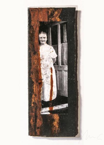 auf einer schwarzen eternitplatte ein S/W-foto einer mittelalten frau in einem weißen kittel mit zurückgebundenen haaren, einem offenen gesicht mit freundlich-sanftem lächeln, die in einer offenen balkontür oder tür zum garten steht. links neben und teils auch auf dem foto gibt es mehrere vertikale rostrote streifen, wie eine angetrocknete flüssigkeit.