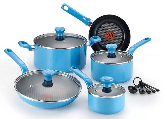 The image displays a set of blue cookware consisting of five pieces, each with a glossy sky-blue finish. The set includes a large saucepan with a lid, a medium saucepan with a lid, a small saucepan with a lid, a frying pan, and a wok pan. Each piece is equipped with a matching blue handle and lid knob. The lids are made of glass with stainless steel rims. The interior of the frying pan is black with a circular heat indicator at the center. Additionally, there is a set of four black measuring spoons, each of different sizes, connected by a ring.