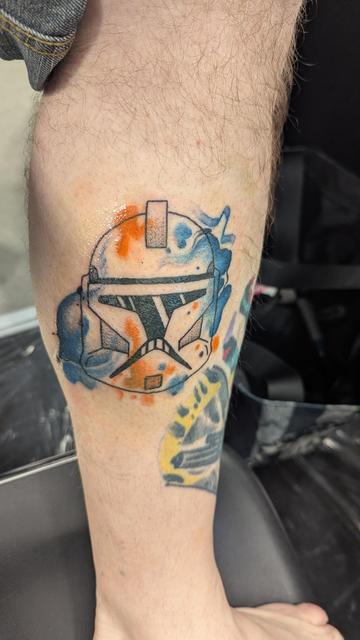 Picture of a leg with a phase 1 clone trooper helmet in outline with splotches of blue and orange in watercolor style over it.