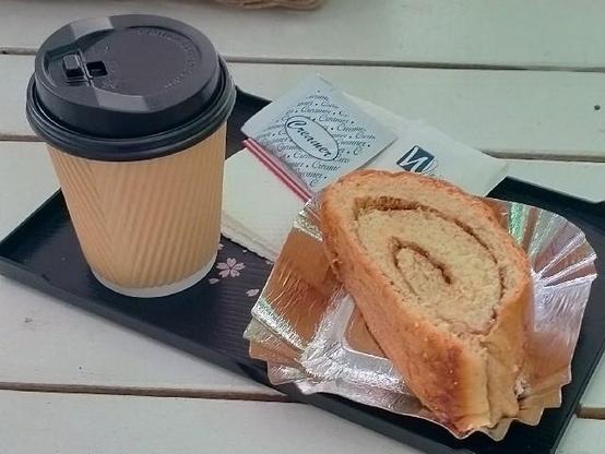 Coffee in a paper cup served with bread