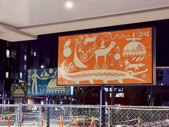 Mosaic artworks of various animals in different solid colors under a future elevated train station