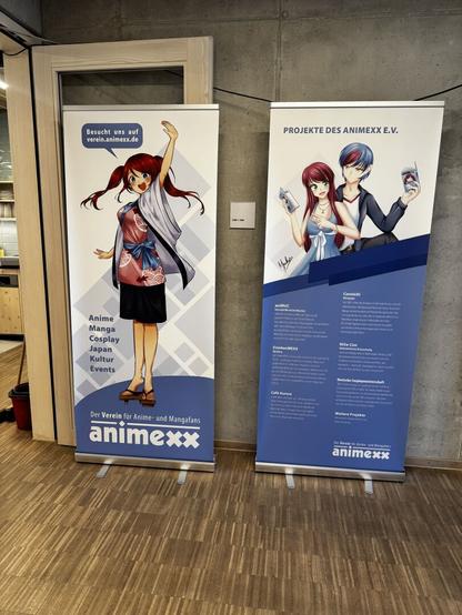 Zwei Rollbanner des Animexx e.V - Links begrüßt das weibliche Maskottchen Aiko mit roten Haaren die Besuchenden - Rechts ist eine Übersicht der Messen, die der Verein organisiert.