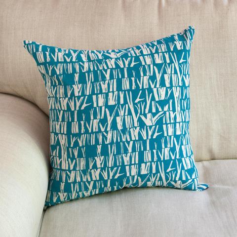 A hand printed cushion with tree branches abstract print.