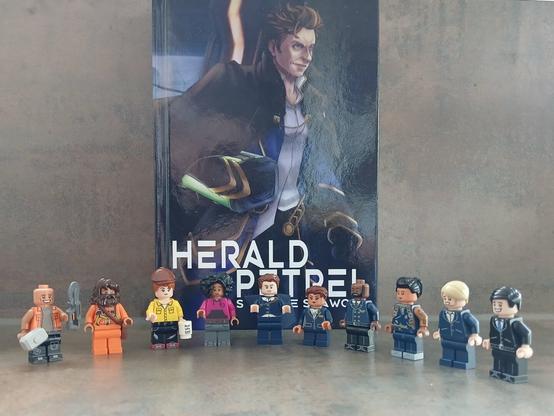 The crew of the Herald Petrel as lego minifigs standing in front of the hardcover edition of the book.