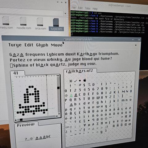 a camera picture of a screen showing turye, a rom running on a raspberry pi on the uxn emulator. the app is for editing fonts at a pixel level and is currently editing the letter A on a small railcar.