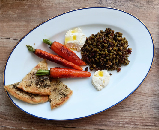 Das fertige Gericht auf dem Teller - 3 Stücken Pitabrot, 3 Möhren, eine Portion Mungobohnen und zwei Kleckse Labneh