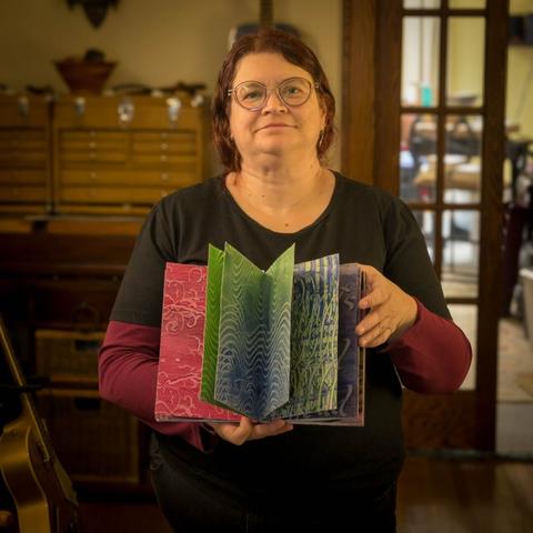 Apprentice bookbinder showing off her newly made drumleaf binding