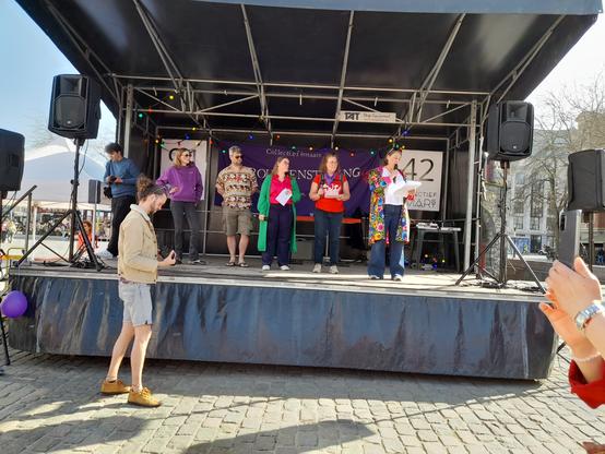 Een podium met daarop 5 mensen, 4 vrouwen en 1 man.