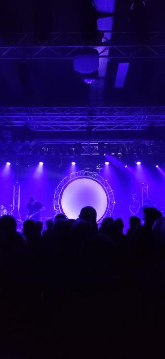 Pink Floyd Tribute Band »Kings of Floyd« in der Oldenburger Kulturetage. Bühne in blau violettem Licht. "Pinkfloyd'eske" runde Projektionsfläche für Licht und Videos.