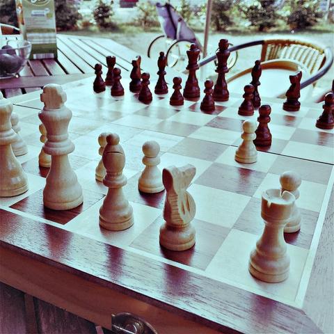 "This picture shows a chess board set up for a game, with multiple pieces in various positions."