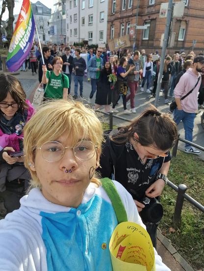 Selfie, viele Menschen auf einem Demonstrationszug, hinten links eine Regenbogenflagge der Grünen Jugend Hessen.