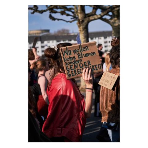 Foto: Beschriftung Schild: Wir wollen keine Blumen, sondern Gender gerechtigkeit