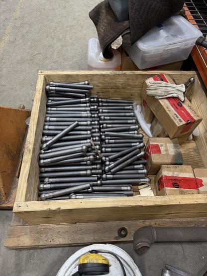 A wooden crate full of flexible staybolts, rods of metal with a ball on one end