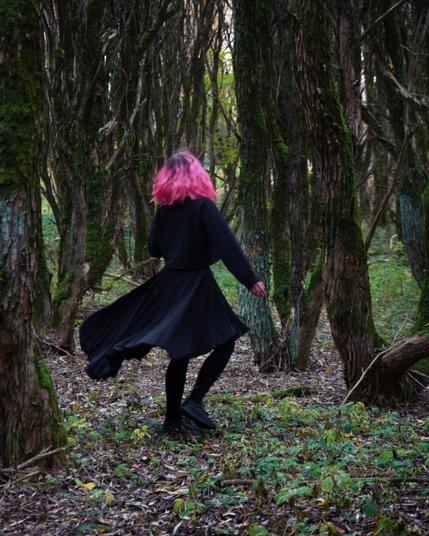 Pink haired woman dancing in an autumn forest