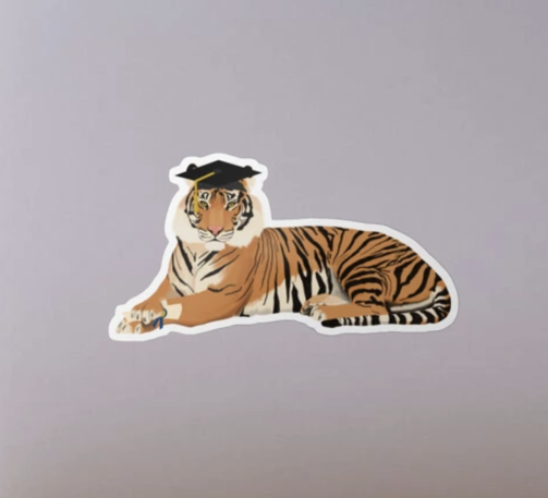 Our tiger mascot is graduating, wearing a mortarboard and holding a diploma.