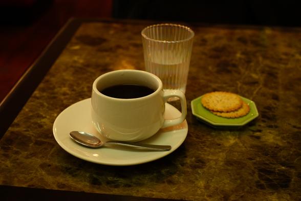 White coffee mug with water and two Harvest cookies.