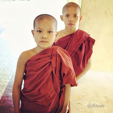 Two Novice Monks Wearing Saffron Colored Robes in a Monastery in Mandalay, Myanmar.