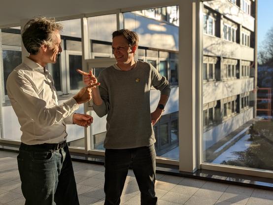 Marc und Thilo stehen lachend vor dem Saaltrakt des Lübecker Gerichtshauses. Sie zeigen mit dem Finger aufeinander, wie im Spider Man Double Meme.