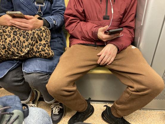 Photo prise dans le métro à Rennes. On y voit un jeune homme assis (buste et pieds, pas la tête), il a les cuisses et genoux écartés, il occupe une place bien plus grande que celle dont il a besoin. #manspreading)
