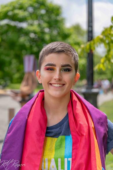 A young woman with perfect makeup and pixie cut hair smiles for the camera at the Seattle Pride Festival.