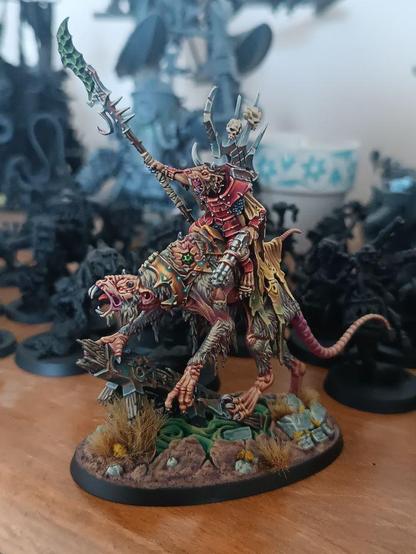 a skaven clawlord on gnaw-beast, painted with a lot of yellows and magentas.