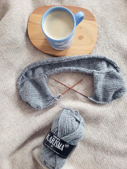 DEU Ein gerade angefangenes Strickprojekt aus hellgrauer Wolle. Die Passe ist fast fertig gestellt.

ENG A knitting project: the yarn is light grey and the yoke is nearly finished.