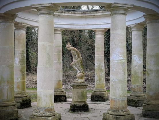 Vue rapprochée sur la nymphe sculptée au centre des colonnades.