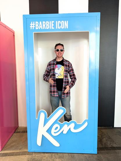 Me wearing jeans, a plaid shirt & Madonna t-shirt inside a life-sized Ken box
