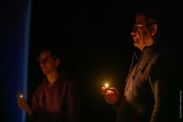 Brieuc Guinard – Break the Cycle (Photo 1)
Deux hommes sont plongés dans l’obscurité, chacun tenant une petite flamme de briquet devant lui. L’un d’eux est plus en retrait, sa silhouette se fondant presque dans le noir, tandis que l’autre est plus nettement éclairé, semblant fixer quelque chose au loin.