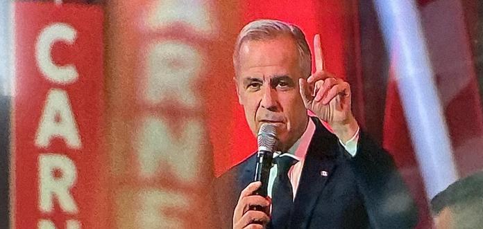 Likely the next prime minister of Canada mark carney raises a finger as he is framed by banners.