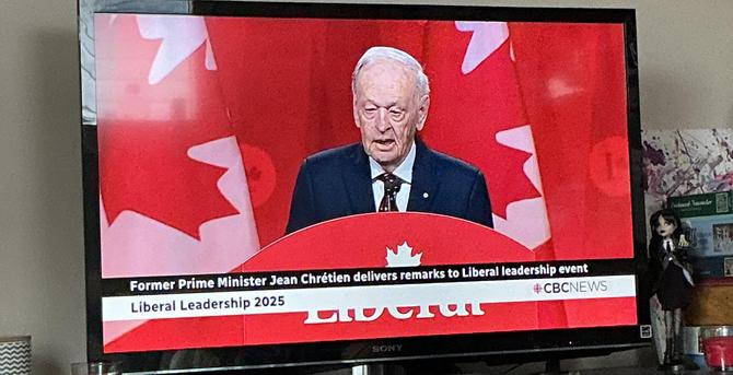 Chretien, an elderly man, speaks at the podium.