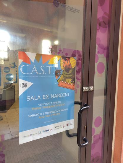 Foto di un manifesto del convegno CAST su una porta a vetri